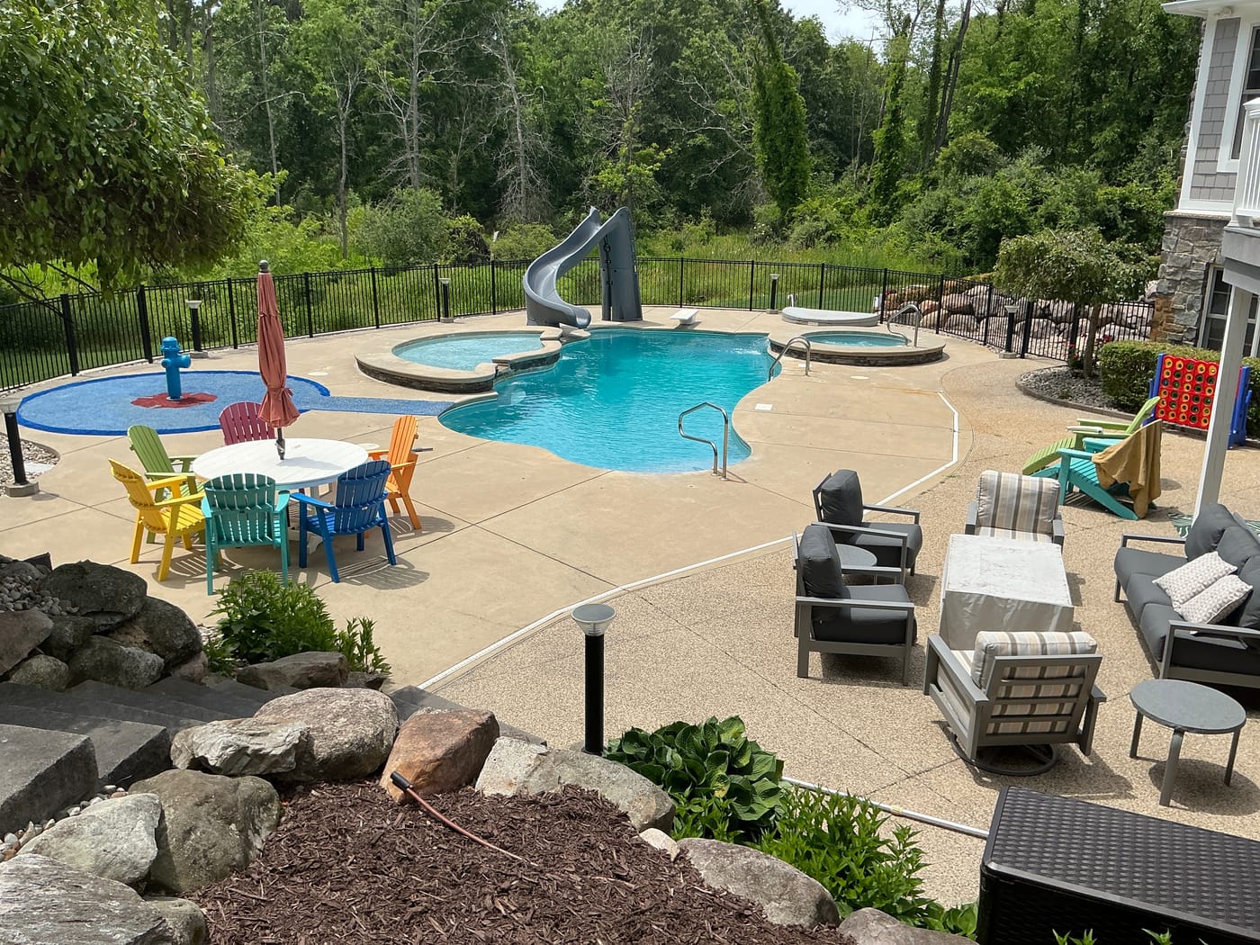 A backyard swimming pool with a slide and spa, serviced by Affordable Pool and Spa